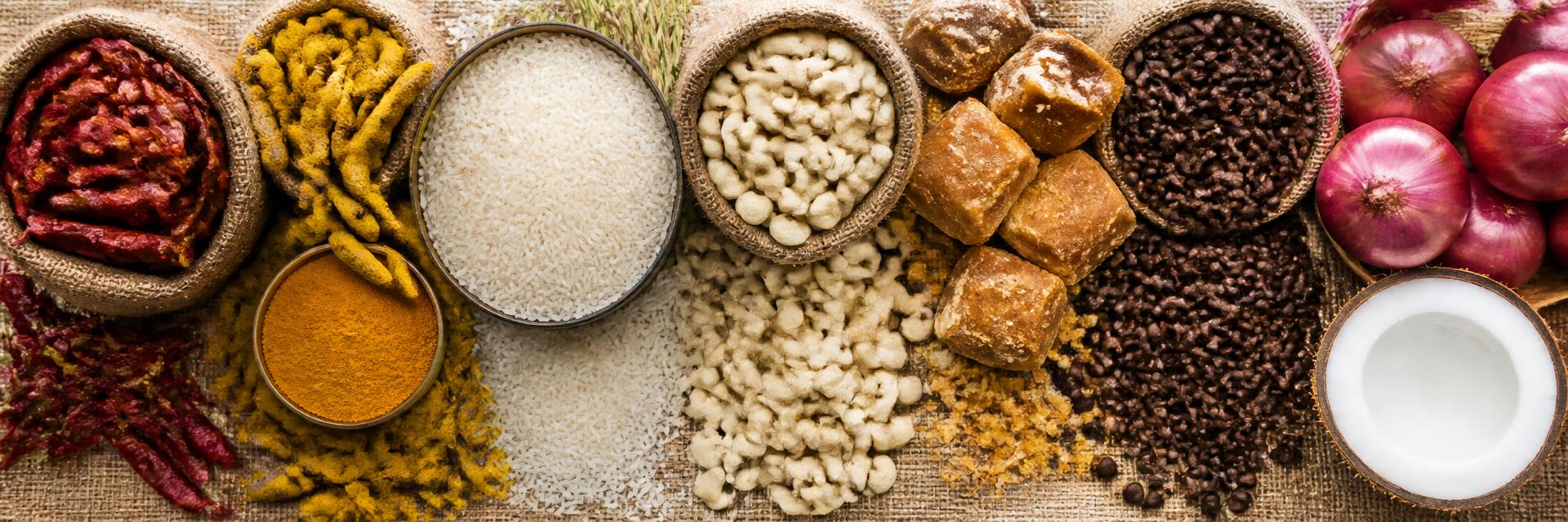 Indian agricultural export commodities — red chilli, turmeric, rice, cashew kernels, jaggery, coffee, onions and coconut — arranged for export packing